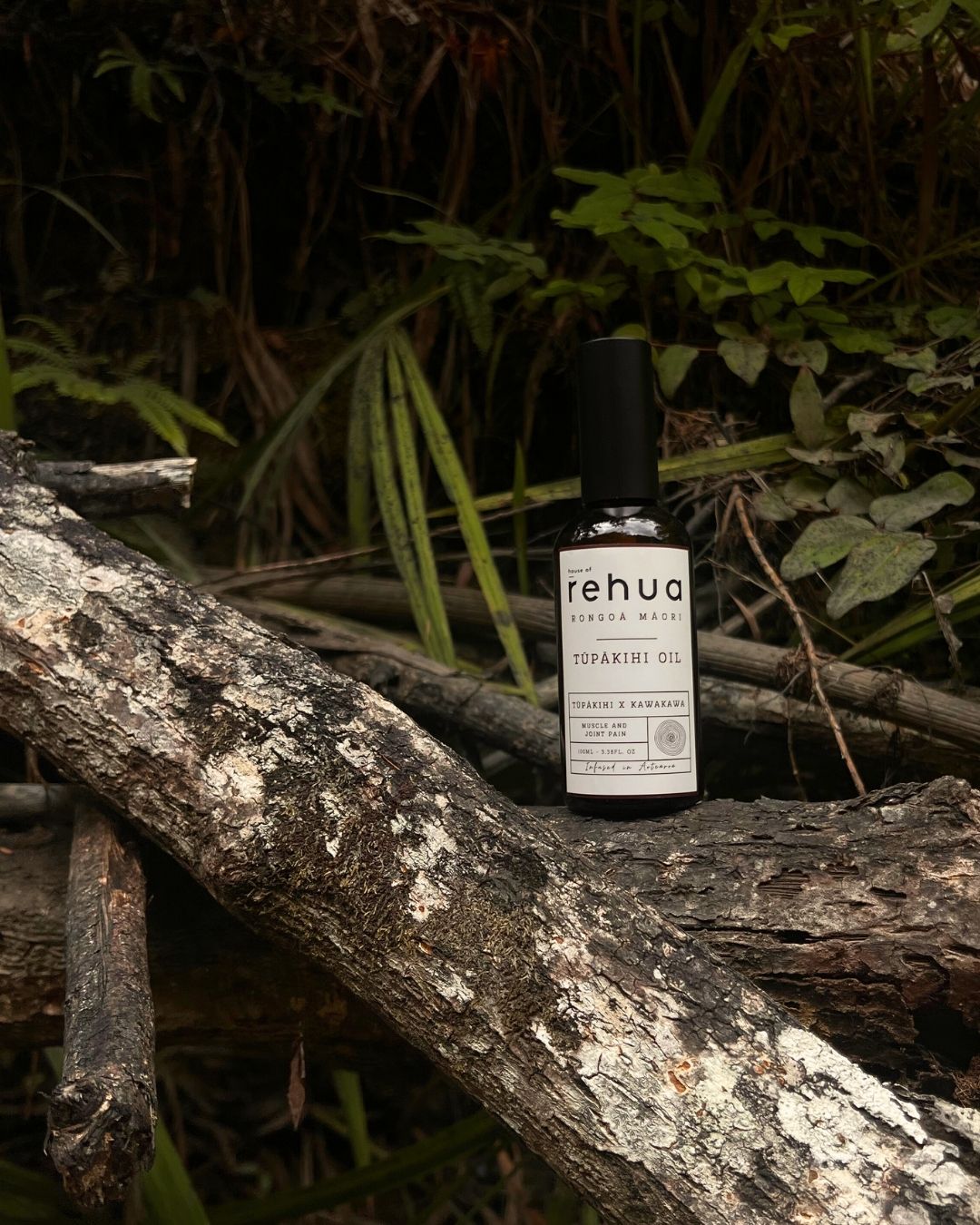 Bottle of Rehua Tupaimo Oil on a wooden log with a natural background