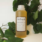 House of Rehua one litre bottle of kawakawa oil with kawakawa leaves in the background