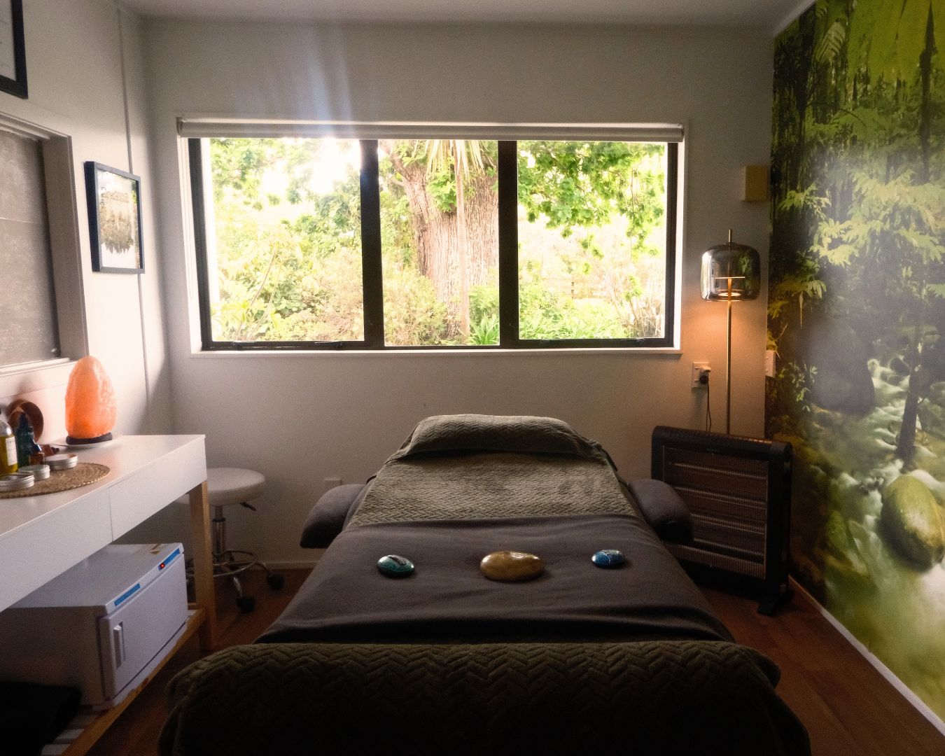 Room with massage table, window, and decorative elements