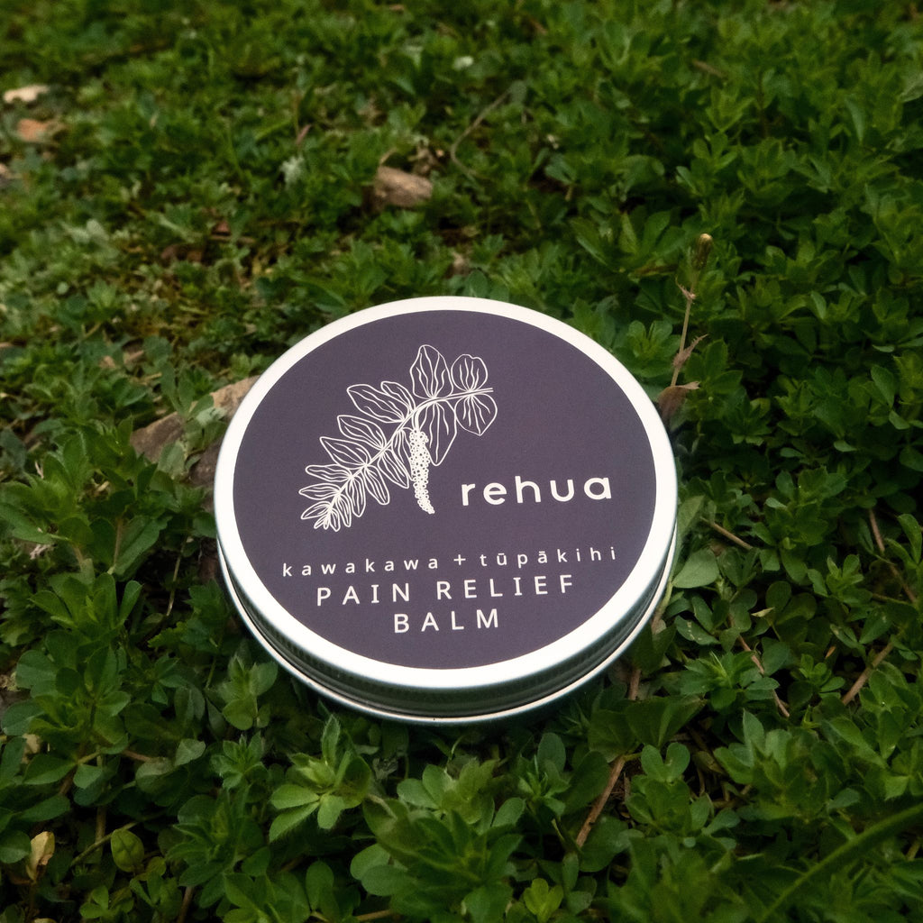 Rehua pain relief balm container on green grass