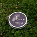 Rehua pain relief balm container on green grass
