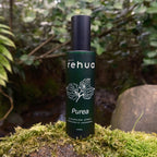 Rehua Purea cleansing spray bottle on a natural background with greenery.