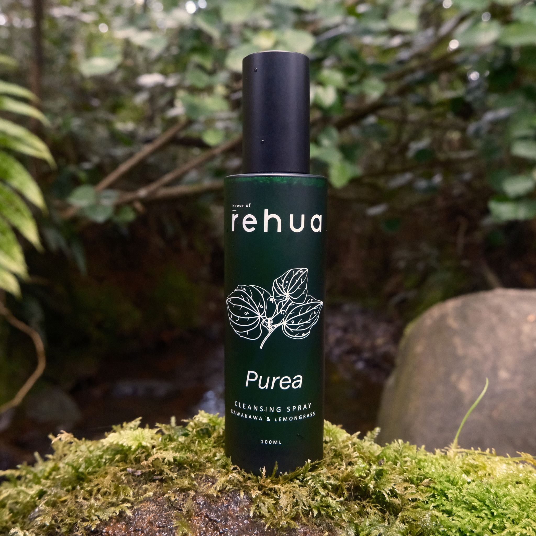 Rehua Purea cleansing spray bottle on a natural background with greenery.