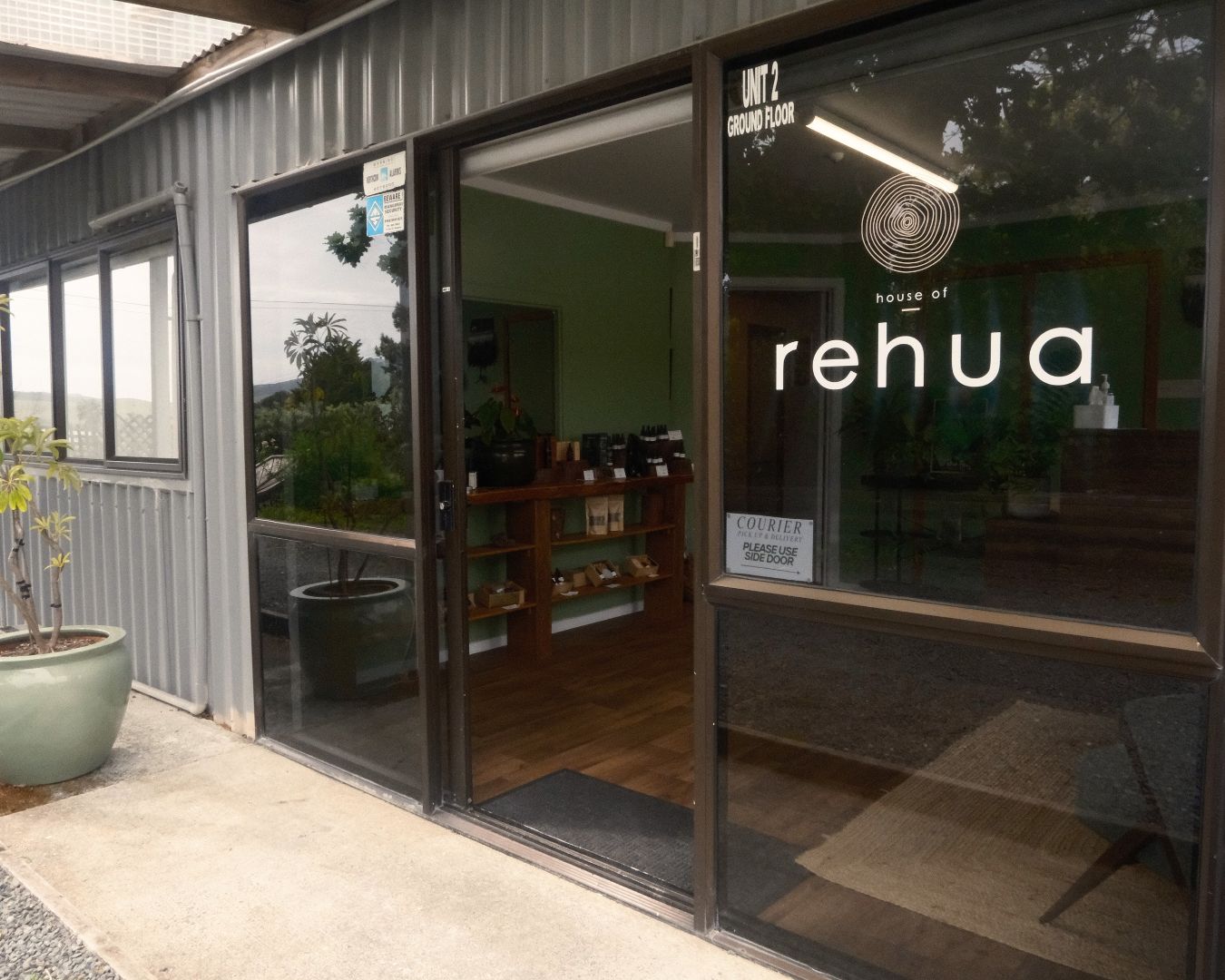 Storefront with 'house of rehua' sign on a clear day