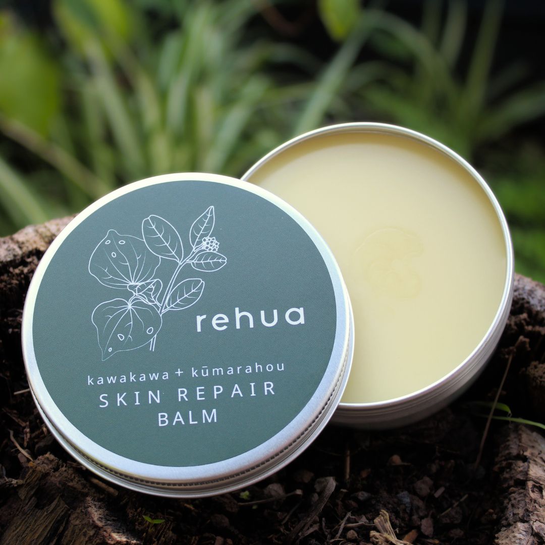 Open tin of rehua skin repair balm with green lid and natural background