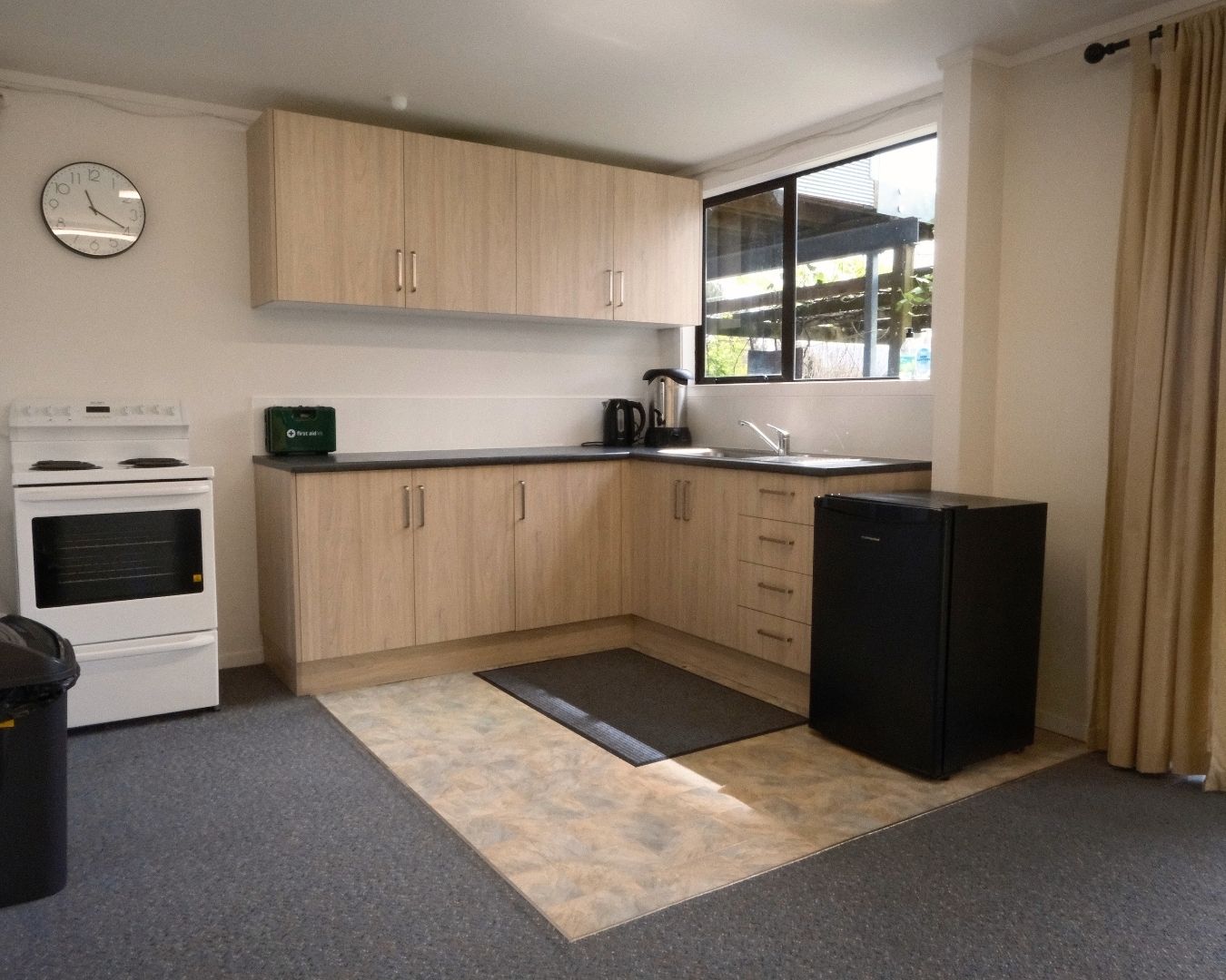 Modern kitchen with wooden cabinets, white stove, and black refrigerator.