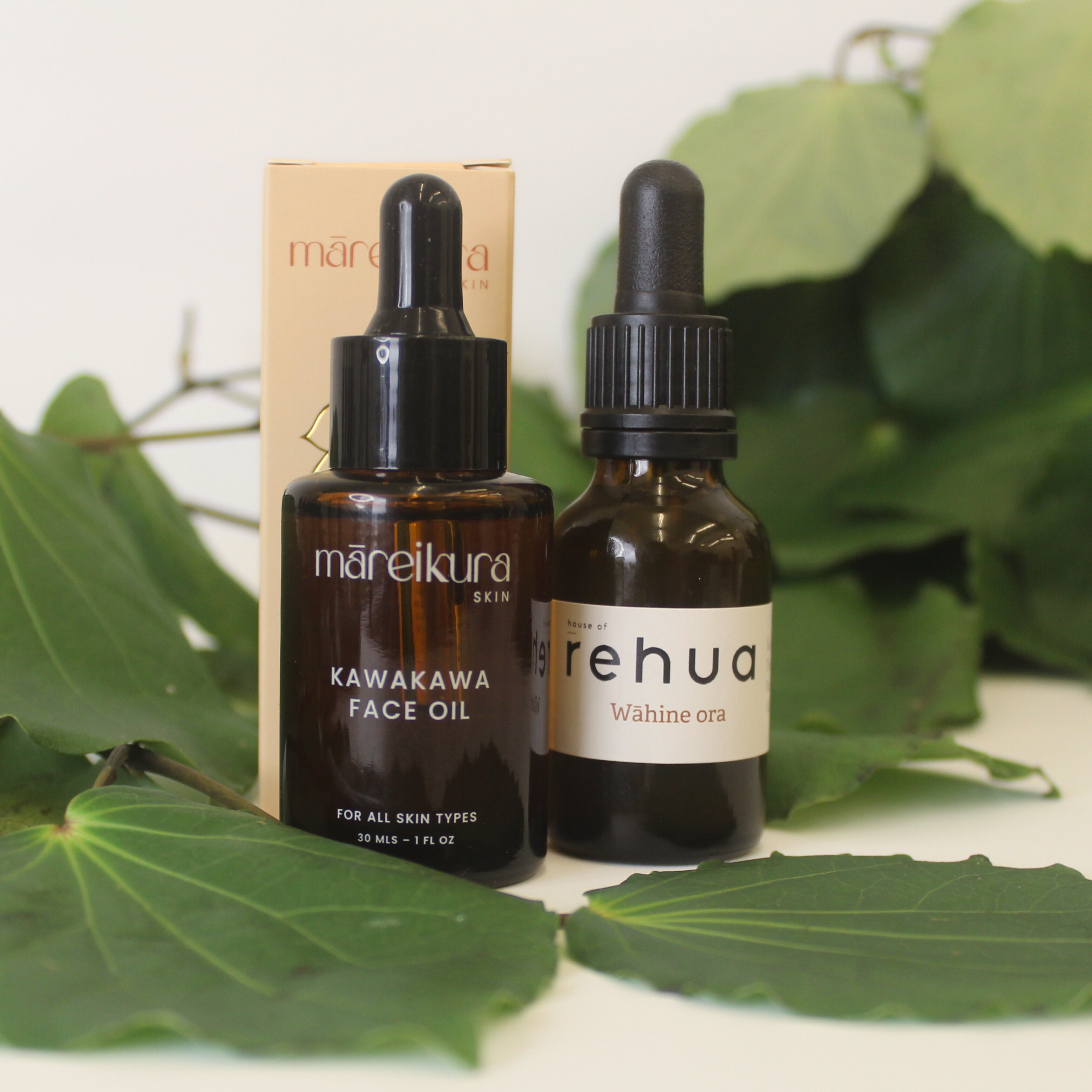 House of Rehua tincture bottle and Māreikura Skin Face oil bottle with kawakawa in the background