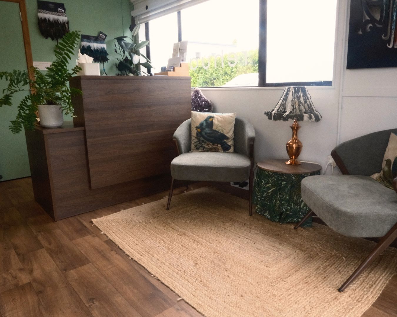 Modern waiting room with wooden furniture, gray chairs, and decorative elements.