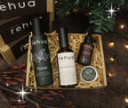 Three 'rehu' skincare products in a box with decorative lights and greenery.