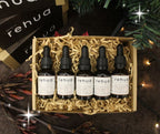 Set of five Rehua bottles in a decorative box with Christmas lights and decorations in the background.