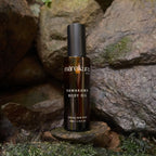Bottle of Mareikura Kawakawa Body Oil on a stone surface with a natural rock background