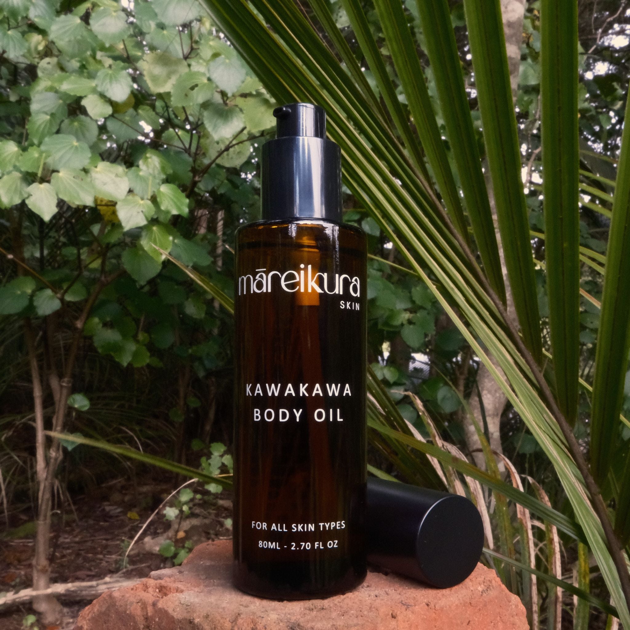 Bottle of mareikura skin Kawakawa body oil on a natural background with greenery.