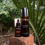 Two bottles of Mareikura skincare products on a rock with green foliage in the background
