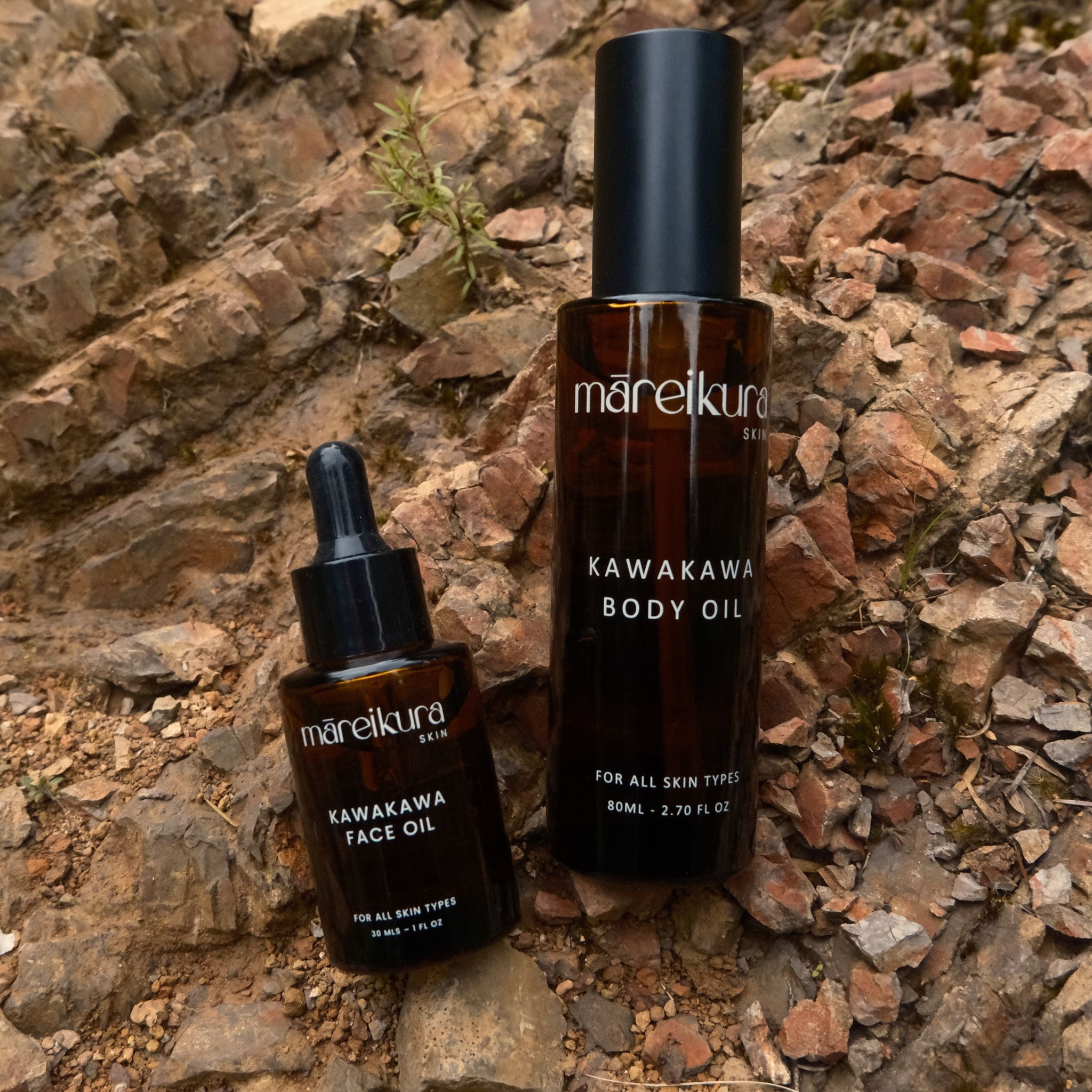 Two bottles of mareikura Kawakawa skincare products on a stone surface