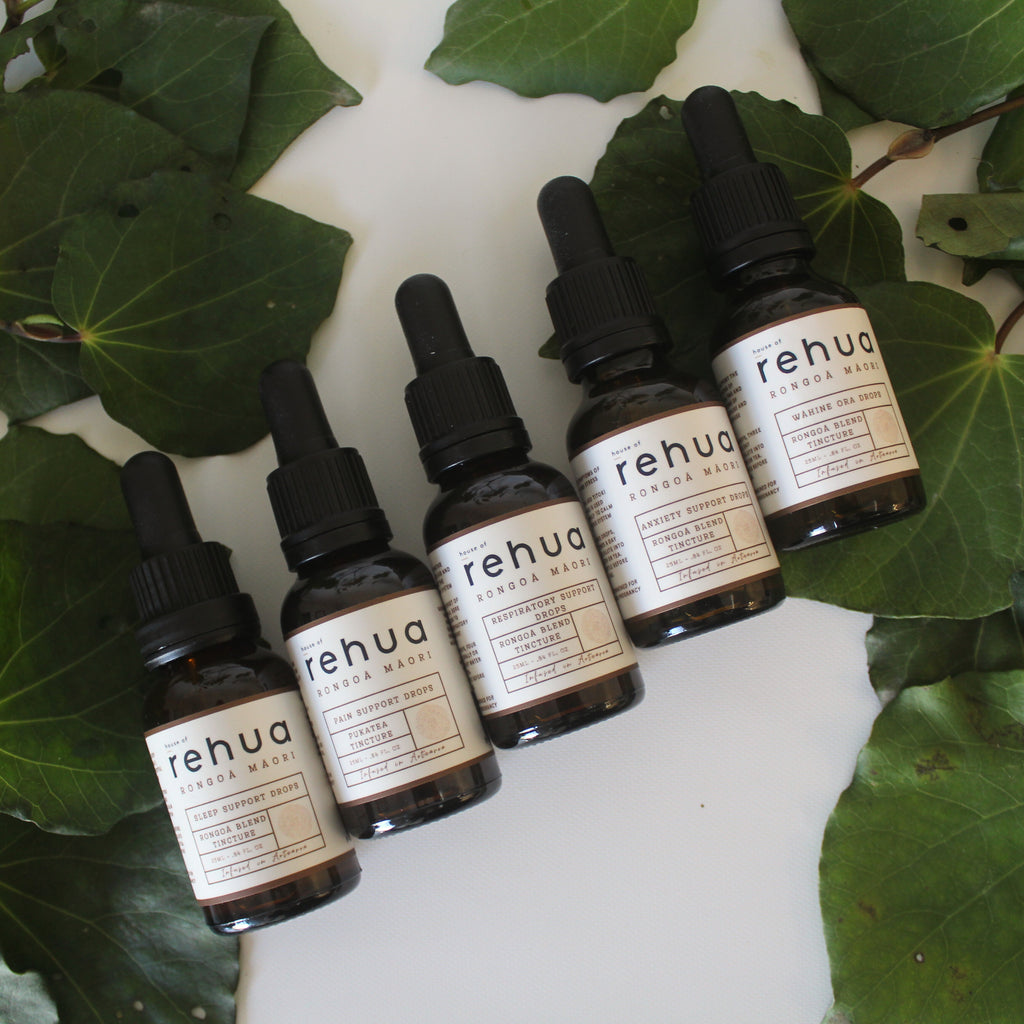 Set of Rehua skincare products on a white surface with green leaves.