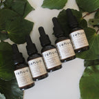 Set of Rehua skincare products on a white surface with green leaves.