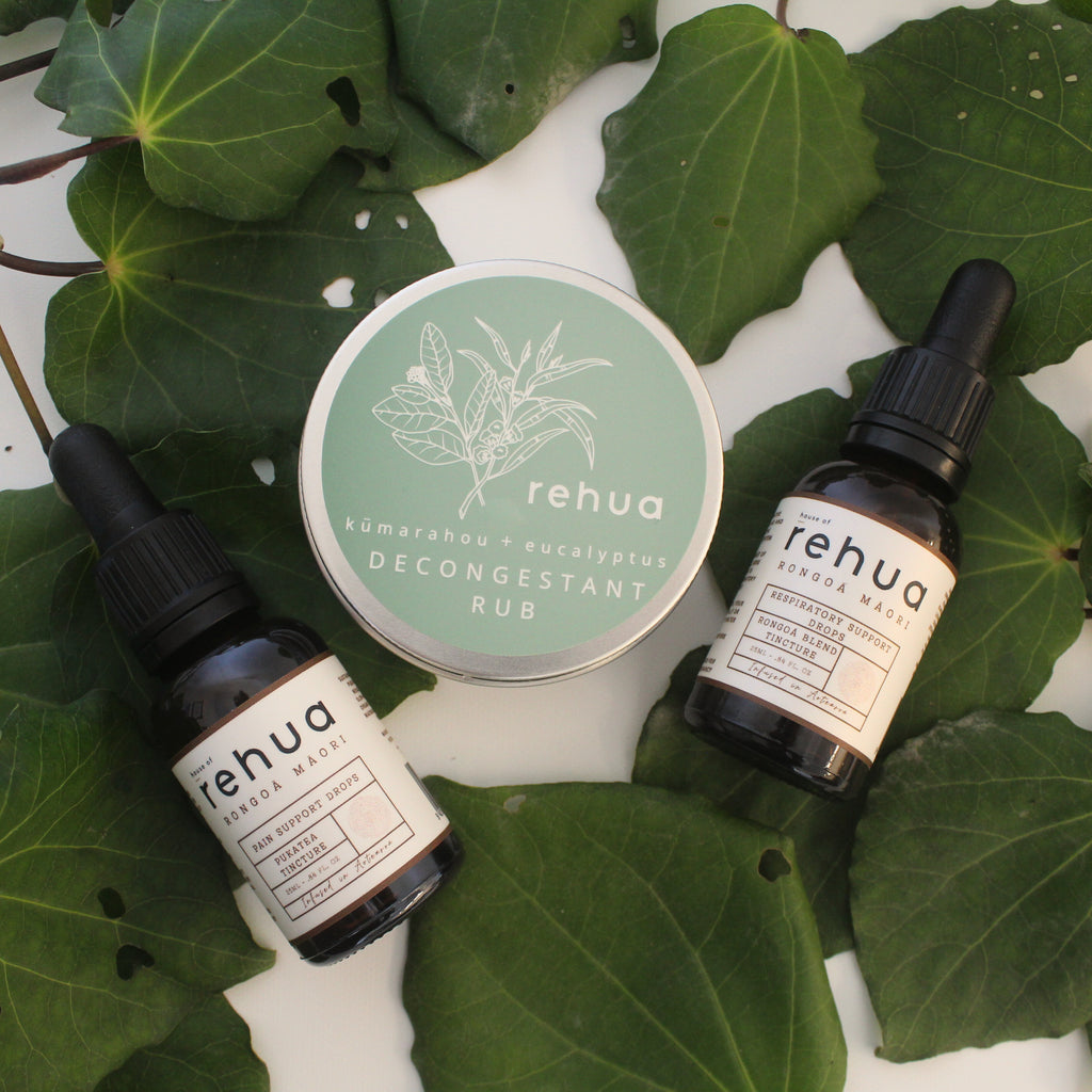 Rehua skincare products including bottles and a tin on green leaves